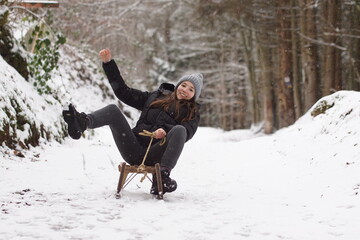 Frau fährt Schlitten im Winter mit fröhlichem Gesicht - es wird so schnell