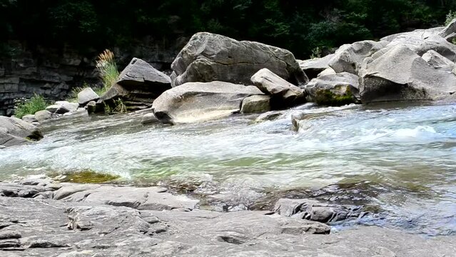 Shot of a mountain river flowing. Stones and water
