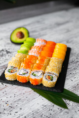 Assorted japanese sushi rolls on black background.