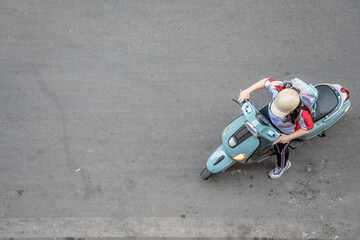 In Hanoi, Vietnam, view from above of a woman on a motorbike.