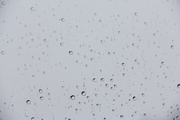 Closeup of rain drops on glass window pane, rainy day window background