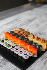 Assorted japanese sushi rolls on black background.