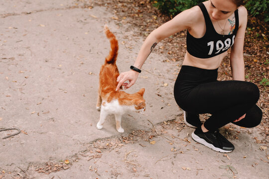 Young woman petting cat outdoors