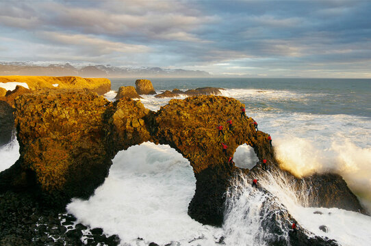 Composite photo of climber bouldering on sea arch, Arnastapi, Snaefellsnes peninsula, Iceland