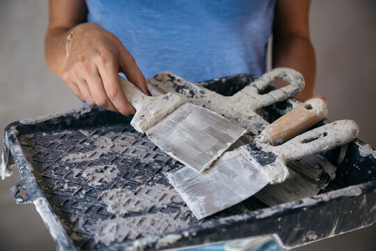 Woman with dirty brick trowels, Tikhvin, Leningrad Oblast, Russia
