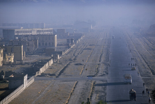 Pollution of dust and smog hang over traffic and ruins along  Darulaman Boulevard, a once elegant part of southwest Kabul, Afgha