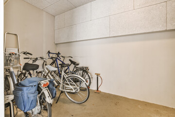 two bikes parked in a room with no one bike on the floor and another standing next to each other bicycles - obrazy, fototapety, plakaty