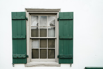 Obraz na płótnie Canvas Green shutters on a window - oldest house St. Augustine Florida. White walls