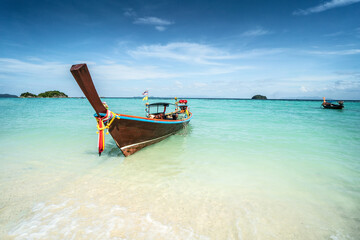 Long tail boat on tropical beach, Koh Lipe island, Thailand. Summer vacation, holiday concept. Blue sky.
