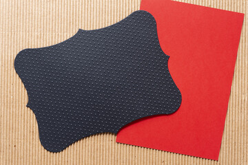 black envelope liner with elegant contours and dotted texture on smooth red and corrugated brown...