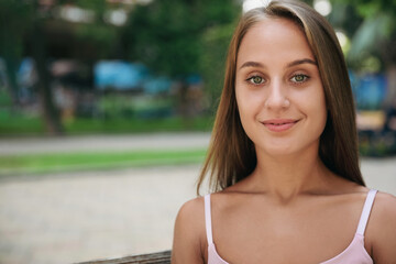 Portrait of beautiful young woman in park, space for text