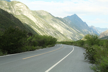 Beautiful view of empty asphalt highway near mountains outdoors. Road trip