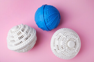 Dryer balls for washing machine on pink background, flat lay
