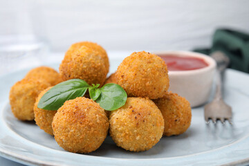 Delicious fried tofu balls with basil and sauce on table, closeup