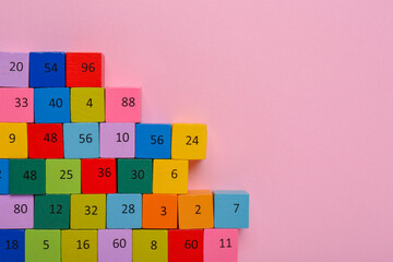 Wooden cubes with different numbers on light pink background, flat lay. Space for text