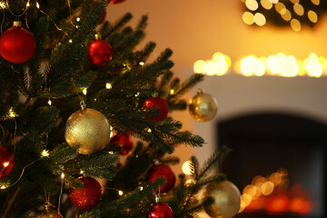 Beautiful Christmas tree decorated with festive lights and baubles indoors, space for text. Bokeh effect