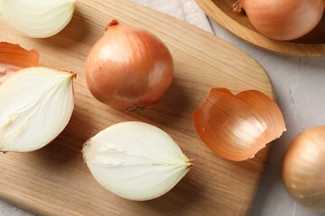 Whole and cut onions on table, flat lay