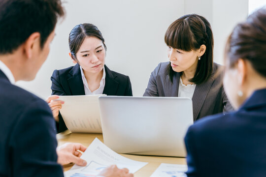 オフィスで困って先輩・上司に相談する後輩・部下のビジネスウーマン
