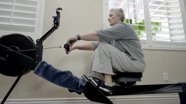 Fit senior woman exercising on a rowing machine