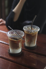 Closeup of Iced Caramel Macchiato at the coffee shop, Caramel Macchiato is a classic macchiato beverage. It consists of vanilla syrup, espresso, steamed milk, foam, and caramel drizzle