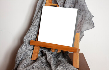 Blank picture on easel with gray drapery. Place to insert a picture