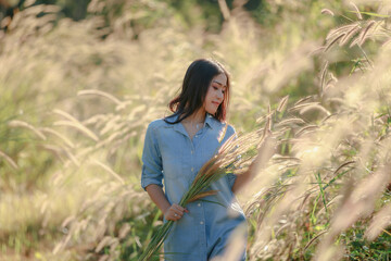 young asian woman in the garden vetiver flowers against natural light late morning