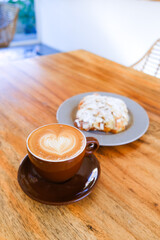 Classic French almond croissant and mug of cappuccino