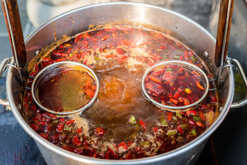 Boiling chili pepper sauce in a cooking pot close-up view in China - 559274138