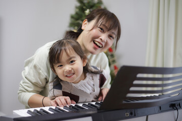 ピアノを弾く練習をする親子