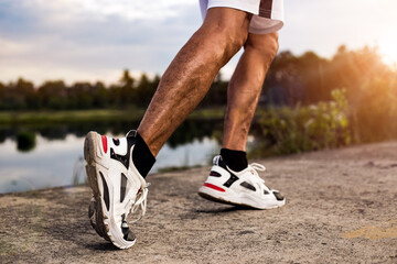 Close up shot of athlete's legs running or jogging on an outdoor concrete road for exercise. Build muscles and for a healthy, concept.