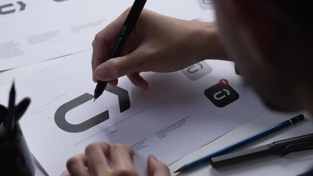 Graphic designer drawing sketches logo design. The concept of a new brand. Professional creative occupation with idea.