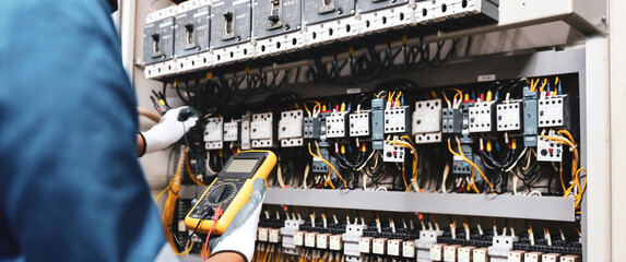 Electricity or electrical maintenance service, Engineer hand checking electric current voltage at...