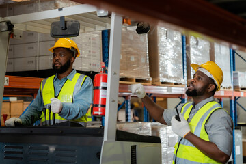Fototapeta na wymiar Two African workers working in a warehouse Organize the product system with a forklift truck. transportation industry.