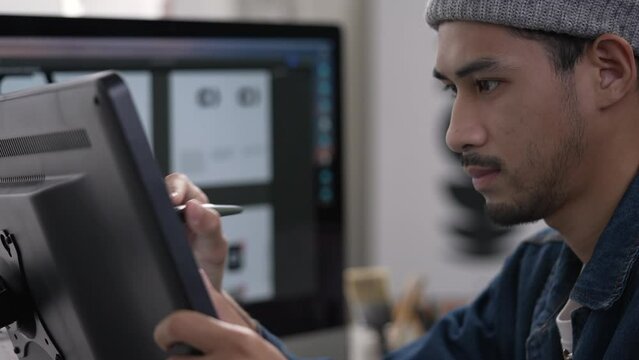 Asian male graphic designer working on computer drawing sketches logo design. The concept of a new brand. Professional creative occupation with idea.