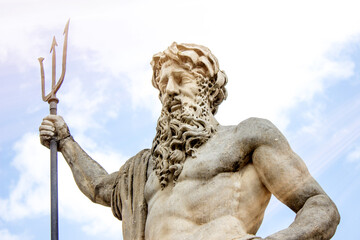 A statue of Neptune in a sunbeam on a blue sky background. Greek mythology © vlady1984