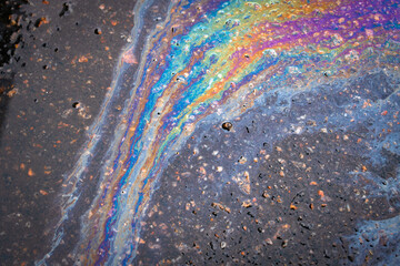 Abstract background from motor oil, gas or petrol spilled on asphalt