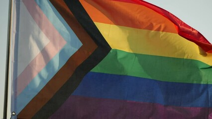 LGBT Rainbow Pride Flag Waving. LGBT, pride, rainbow flag is symbol Gay, Lesbian, Peace, Pride, LGBTQ, Bisexual, Homosexual, Transgender, Love. Rainbow flag waving on sunset, soft focus. Slow motion