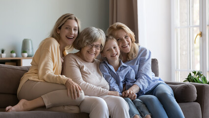 Cheerful female relatives of different ages, generations home portrait. Happy little girl, young...