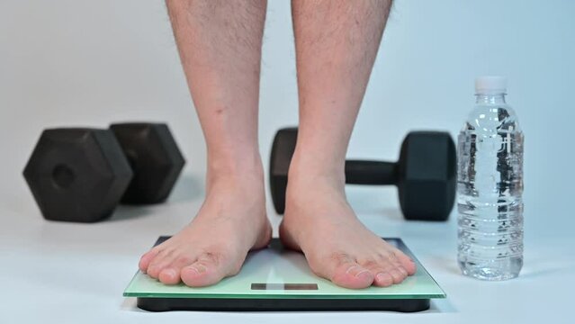 Asian middle-aged man's feet measuring weight