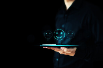 Hand of businessman holding tablet showing to rating score happy icons. Customer service experience...