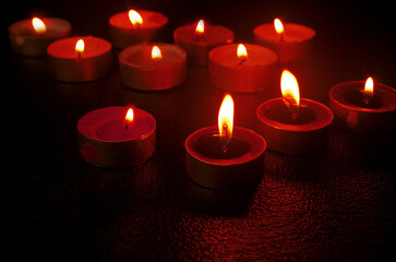 Burning candles to remember the dead. Black background.