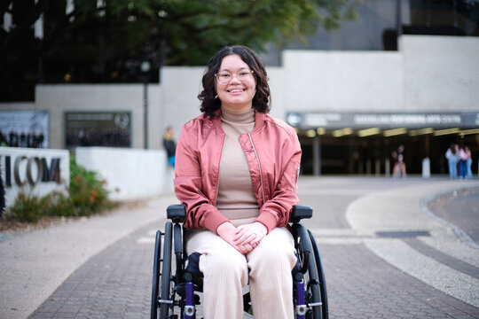 Smiling woman with a disability sitting in a wheelchair outside