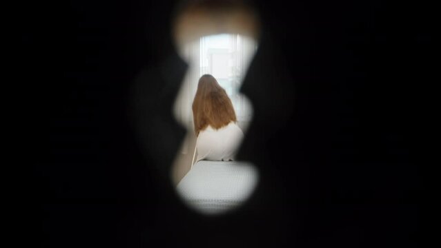 The girl on the bed in the bedroom takes off her negligee and notices me peeping at her through the keyhole, she closes the door with a key.