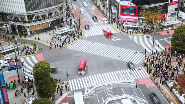 Time lapse of car traffic transportation, crowded people walk cross road at Shibuya scramble crossing. Tokyo tourist attraction landmark, Japan tourism, Asia transport or Asian city life concept