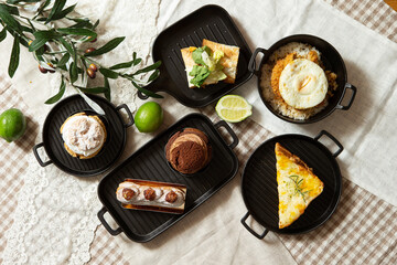 Sandwiches, slices of cake and various desserts on the table