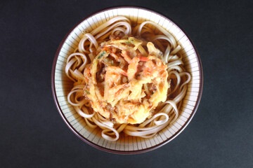 黒背景の天ぷらうどん