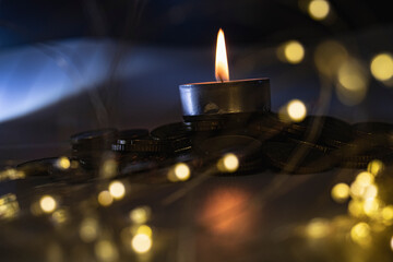 a candle on a dark background with illumination from a garland, the concept of a festive mood