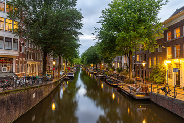 evening view on bloemgracht in amsterdam with lanterns reflecting in the water