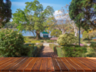 wooden table top on blurred park background.