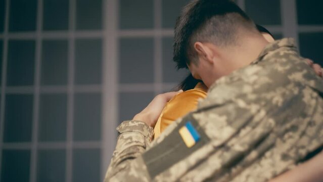Ukrainian wife hugging military husband leaving for war, family separating